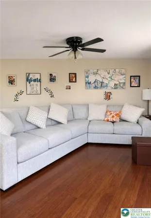 a living room with furniture and a wooden floor
