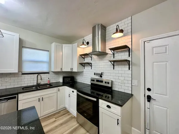 a kitchen with stainless steel appliances a sink stove and cabinets