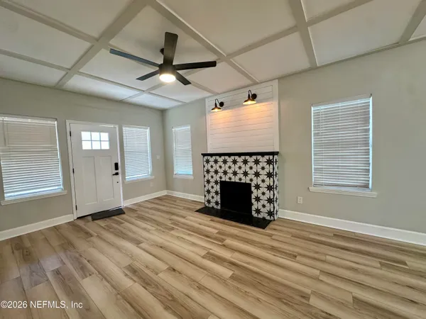 a view of an empty room with a fireplace and a window