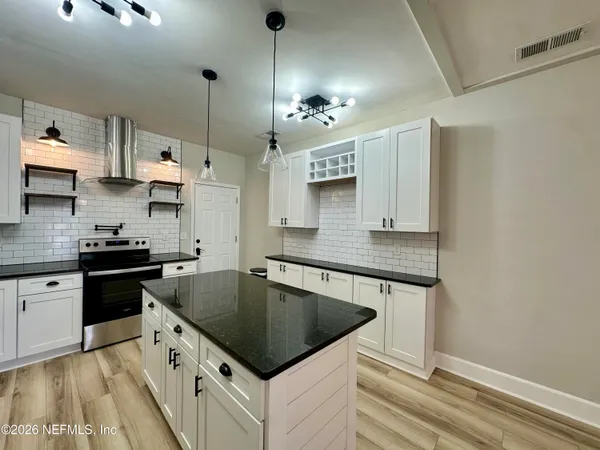 a kitchen with stainless steel appliances granite countertop a sink a stove and a refrigerator