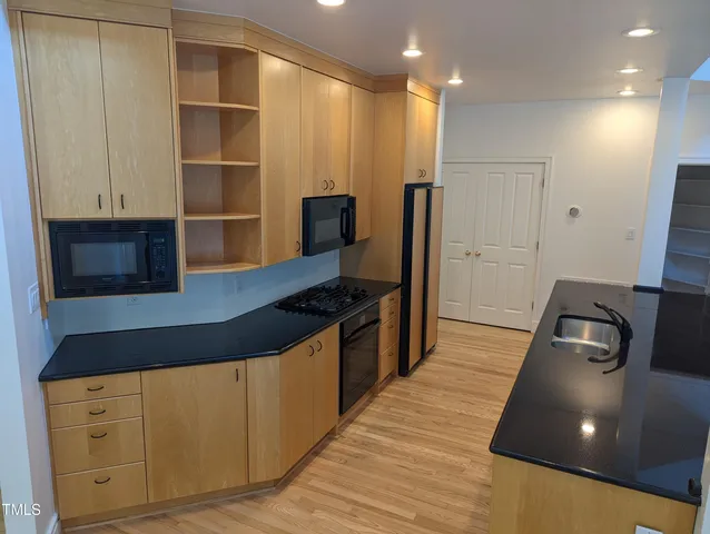 a kitchen with granite countertop a sink and a stove top oven