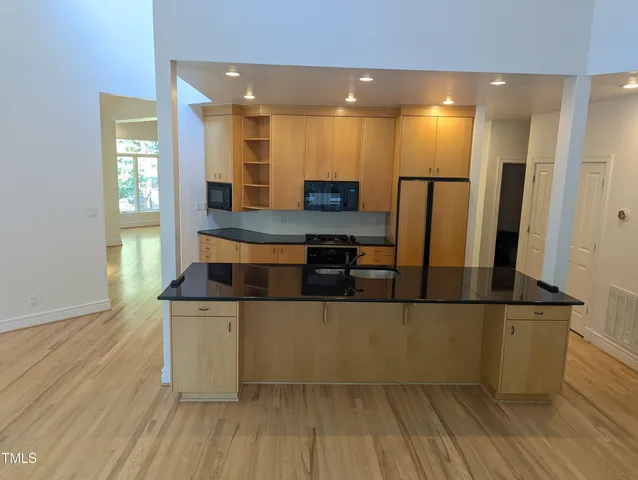 a kitchen with stainless steel appliances granite countertop a refrigerator and a stove top oven