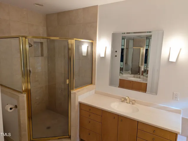 a bathroom with a shower sink vanity and mirror