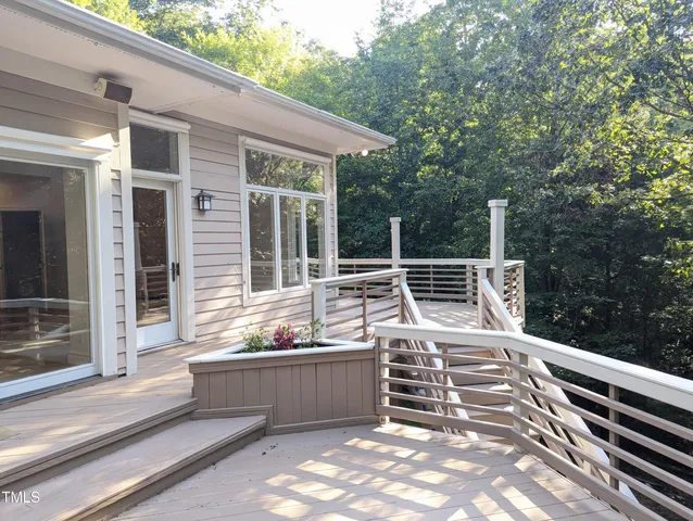 a view of a patio with table and chairs with wooden floor and fence