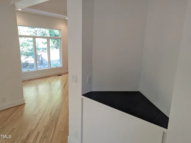 a view of a closet area with wooden floor