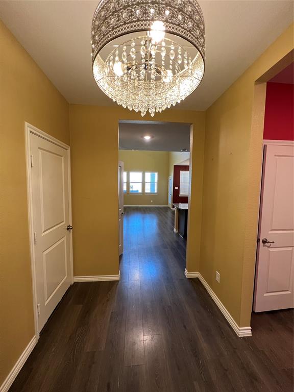 412 Gunsmoke Trail Princeton, TX 75407 - Photo 1 of 28 an empty room with wooden floor a chandelier and windows