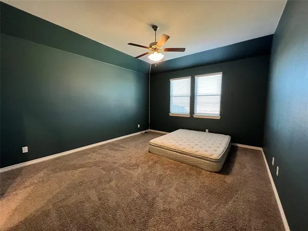a bedroom with a bed and a chandelier fan