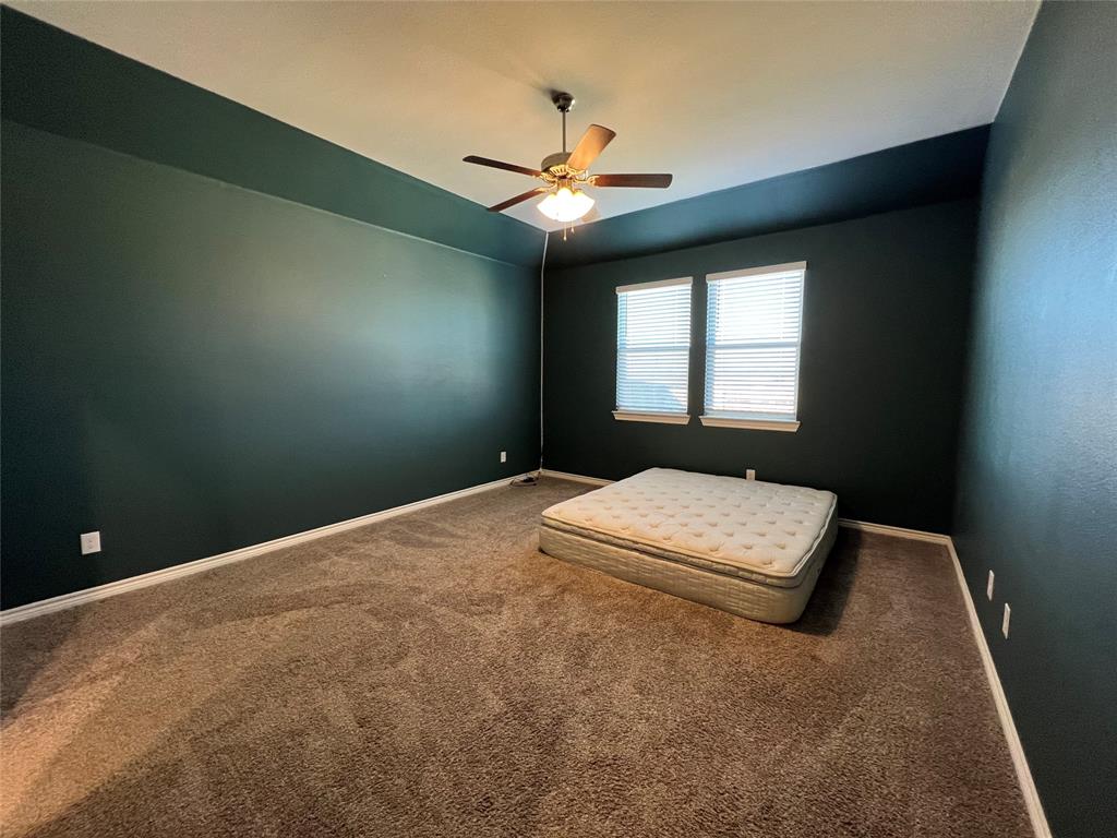 412 Gunsmoke Trail Princeton, TX 75407 - Photo 12 of 28 a bedroom with a bed and a chandelier fan