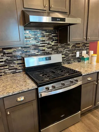 a stove top oven sitting inside of a kitchen