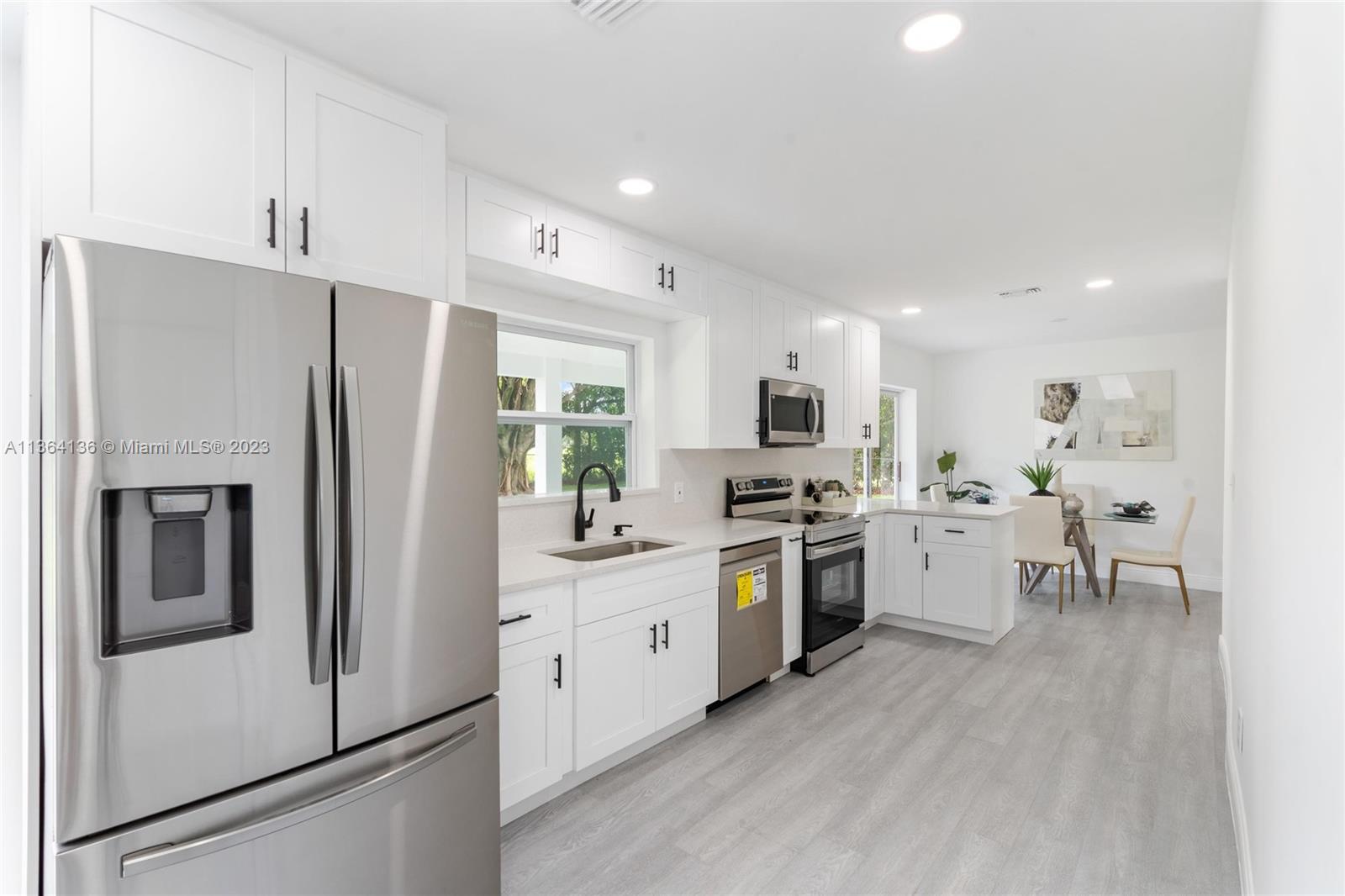7321 Northwest 11th Place Plantation, FL 33313 - Photo 9 of 23 a kitchen with white cabinets and stainless steel appliances