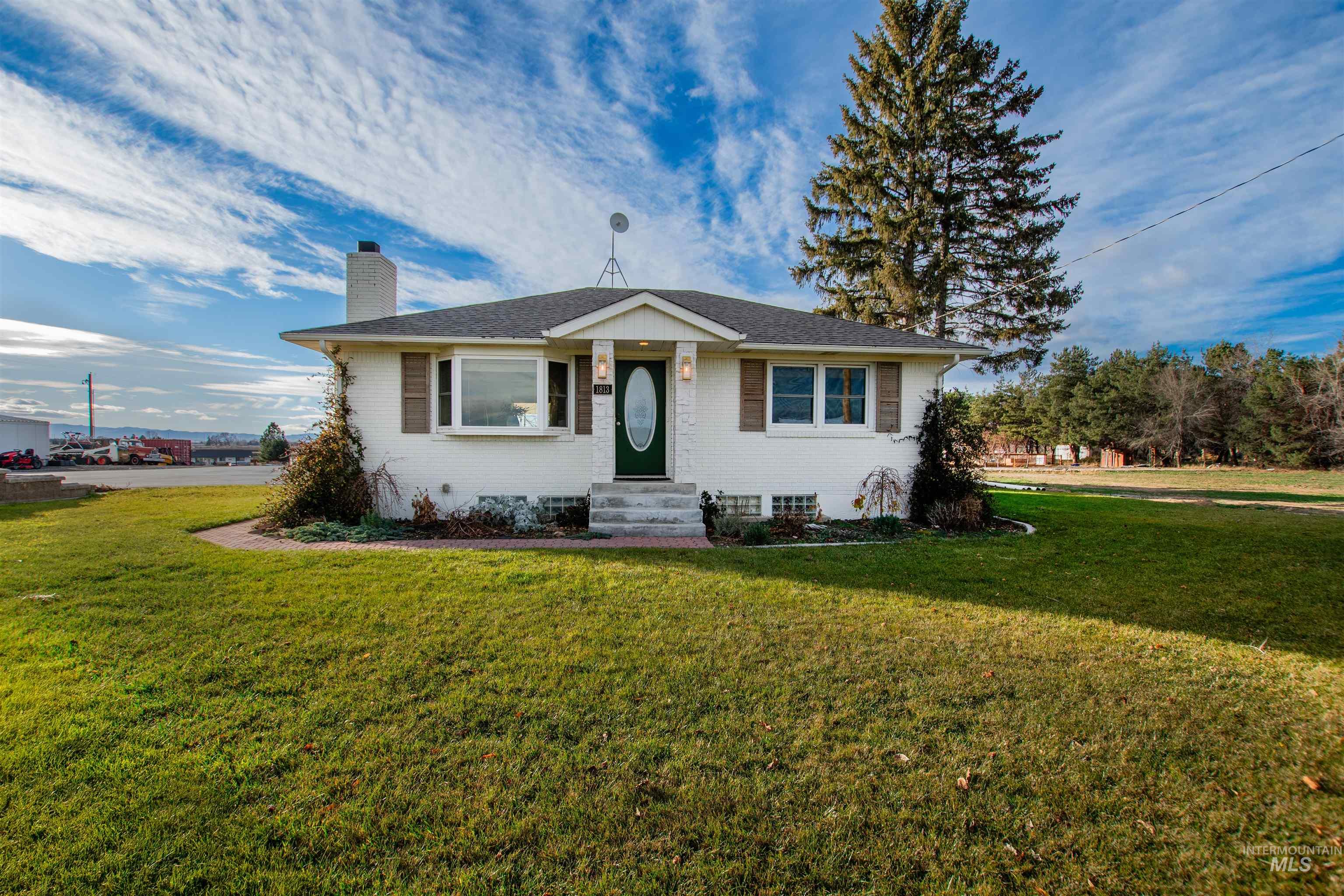 View of front of house featuring a chimney, a front yard, and brick siding