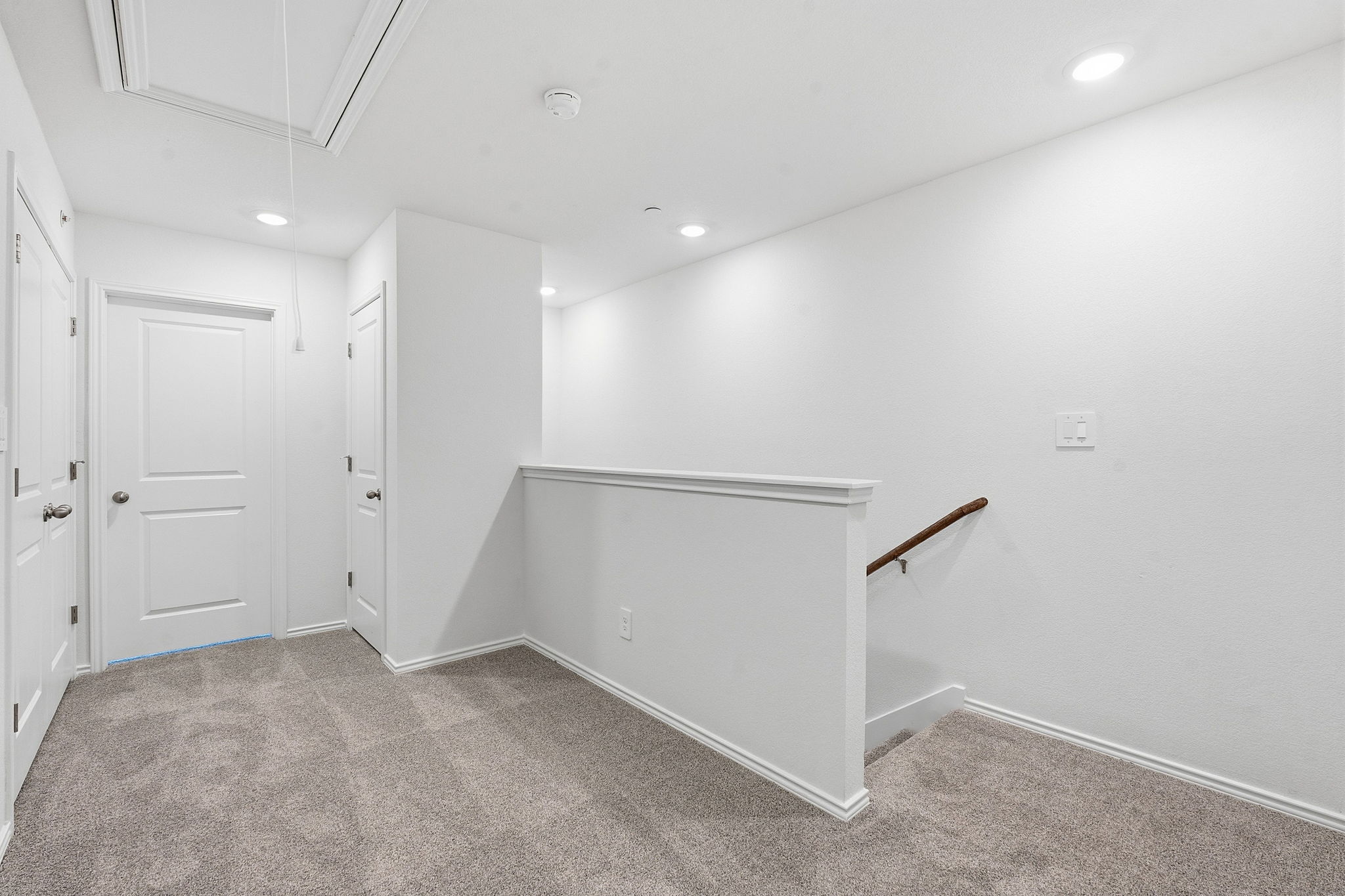 164 Cinnabar Lane, Unit 3 Kyle, TX 78640 - Photo 11 of 20 Carpeted landing with white walls and trim, recessed lighting, and a wooden handrail