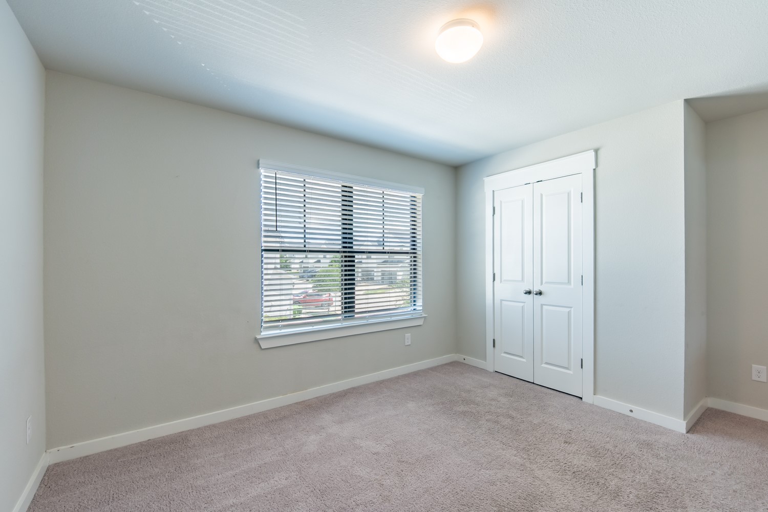 147 Waterside Road, Unit A Buda, TX 78610 - Photo 23 of 27 A well-lit bedroom featuring ample natural light through a large window and convenient closet storage.