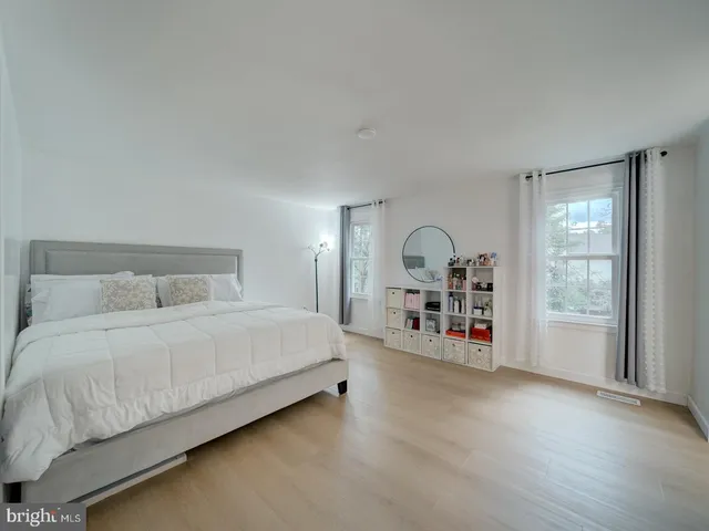 a bedroom with a bed and a large window