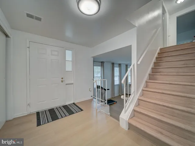 a view of a bedroom with wooden floor and stairs