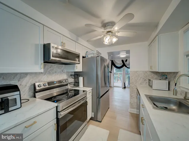 a kitchen with stainless steel appliances a sink stove and refrigerator