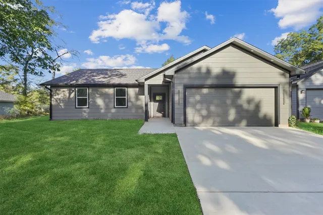 a front view of a house with a yard and garage