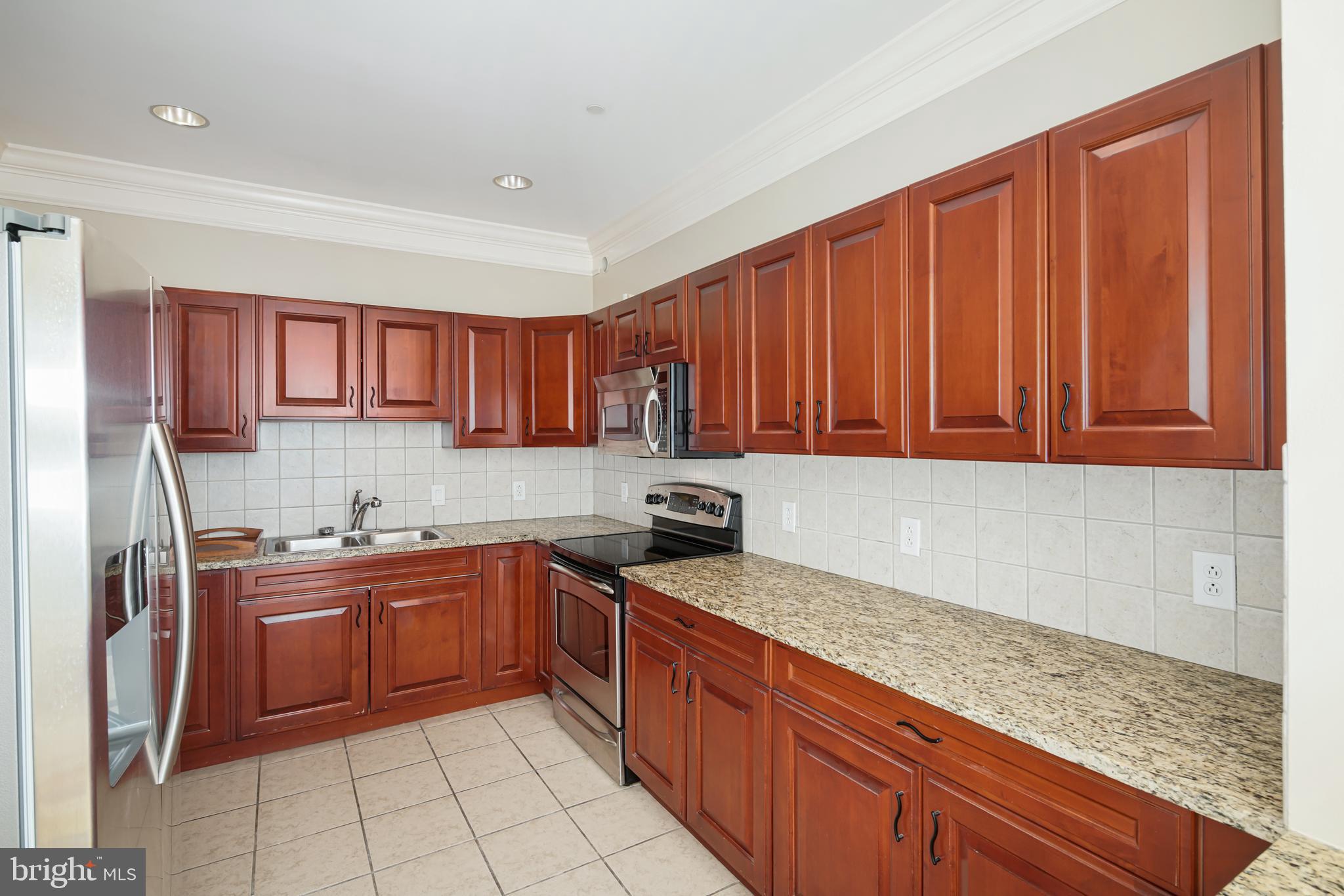 901 North Penn Street, Unit R1902 Philadelphia, PA 19123 - Photo 13 of 34 a kitchen with stainless steel appliances granite countertop a sink stove and refrigerator