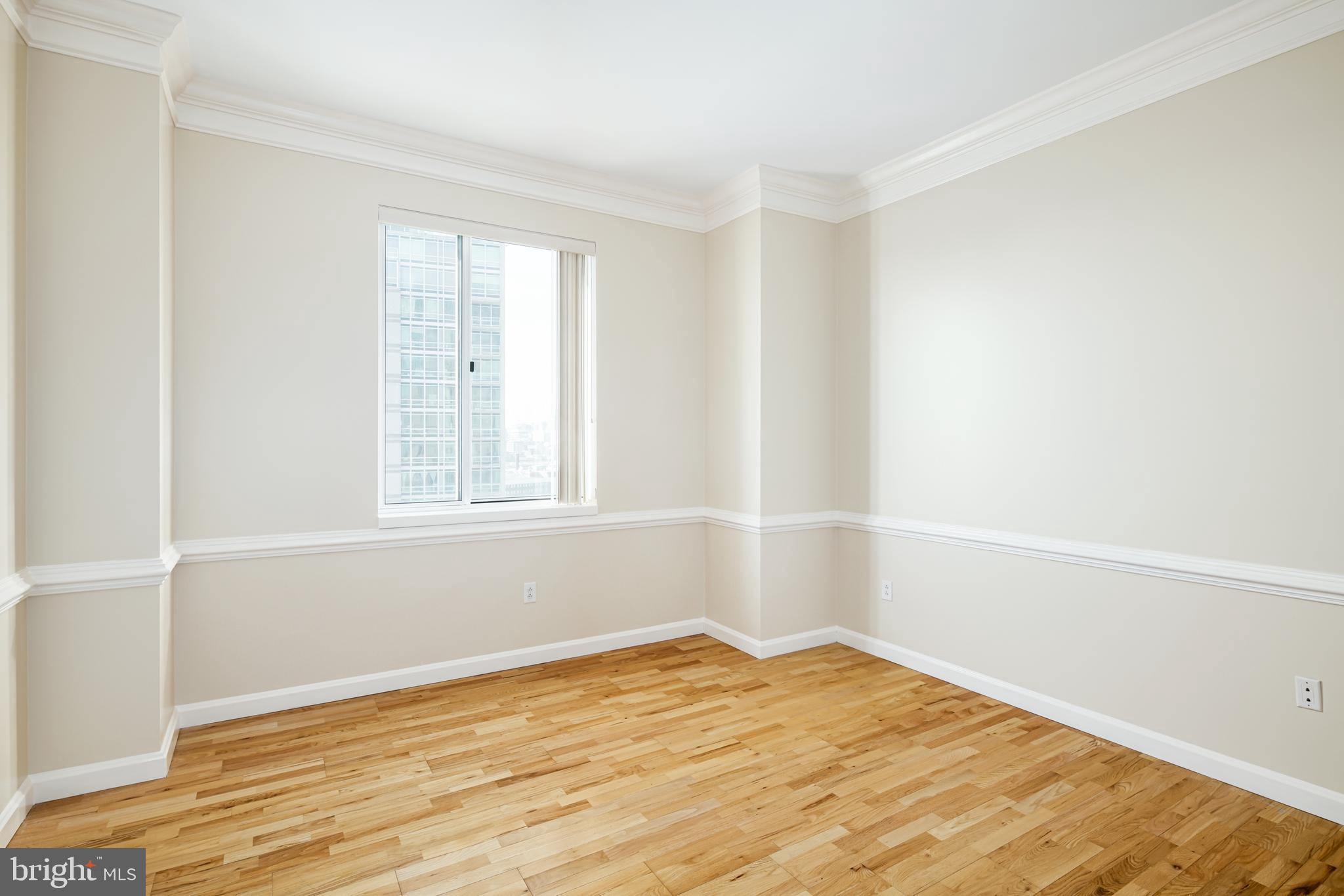 901 North Penn Street, Unit R1902 Philadelphia, PA 19123 - Photo 18 of 34 a view of an empty room with wooden floor and a window
