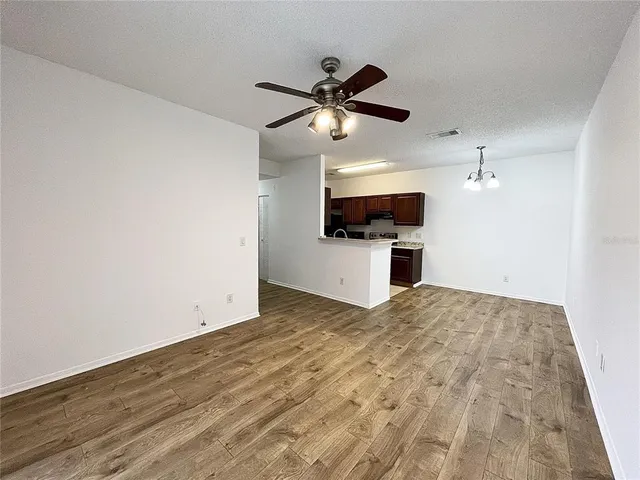 a view of empty room with a ceiling fan and wooden floor