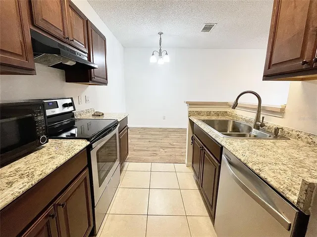 a kitchen with stainless steel appliances granite countertop a sink stove and cabinets