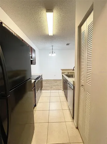 a large kitchen with stainless steel appliances kitchen island a large counter top a sink and a stove