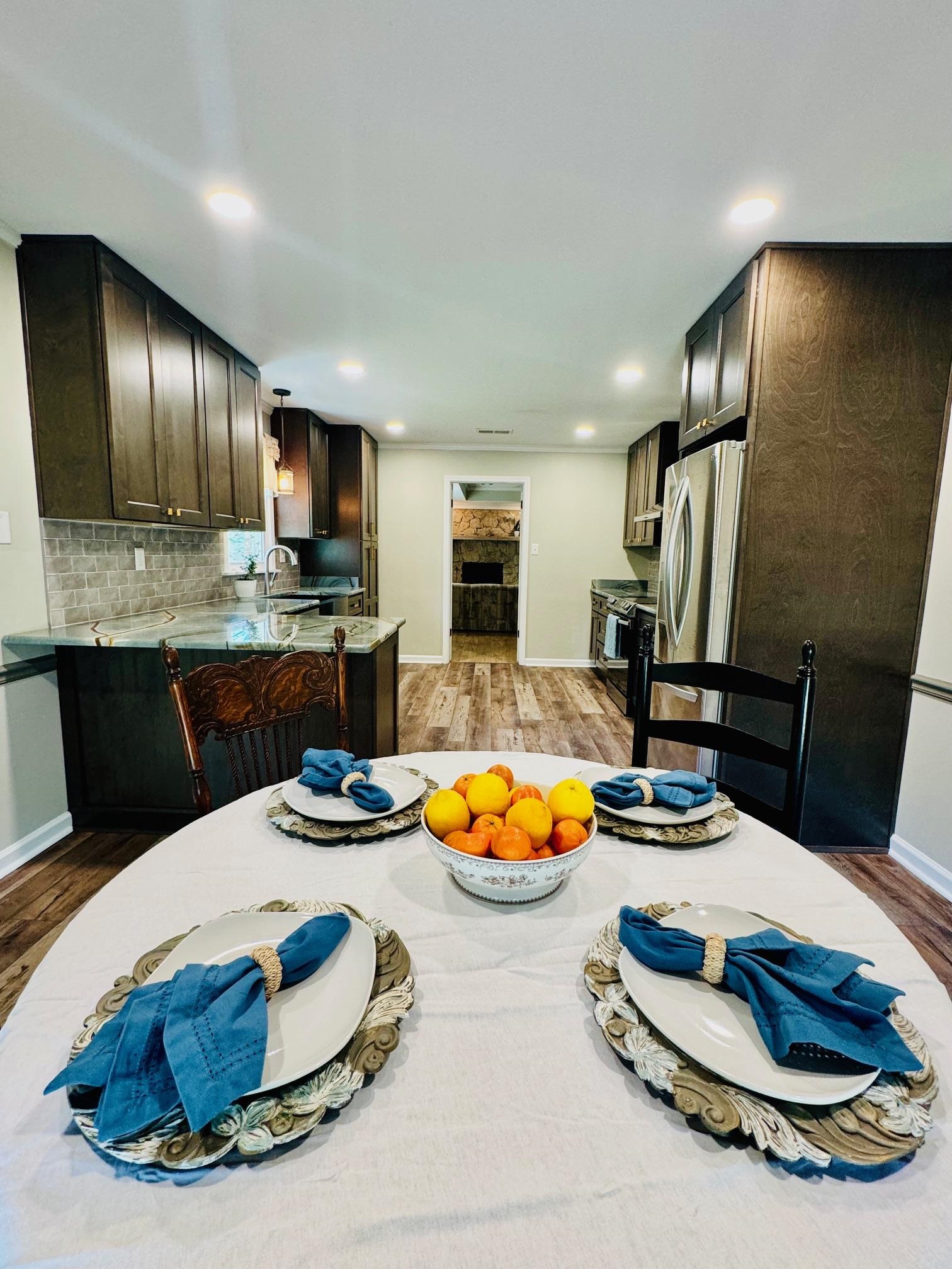 641 Hermitage Trail Collierville, TN 38017 - Photo 13 of 24 Kitchen featuring dark wood finish cabinets, dark wood-style floors, freestanding refrigerator, light stone countertops, and black range oven
