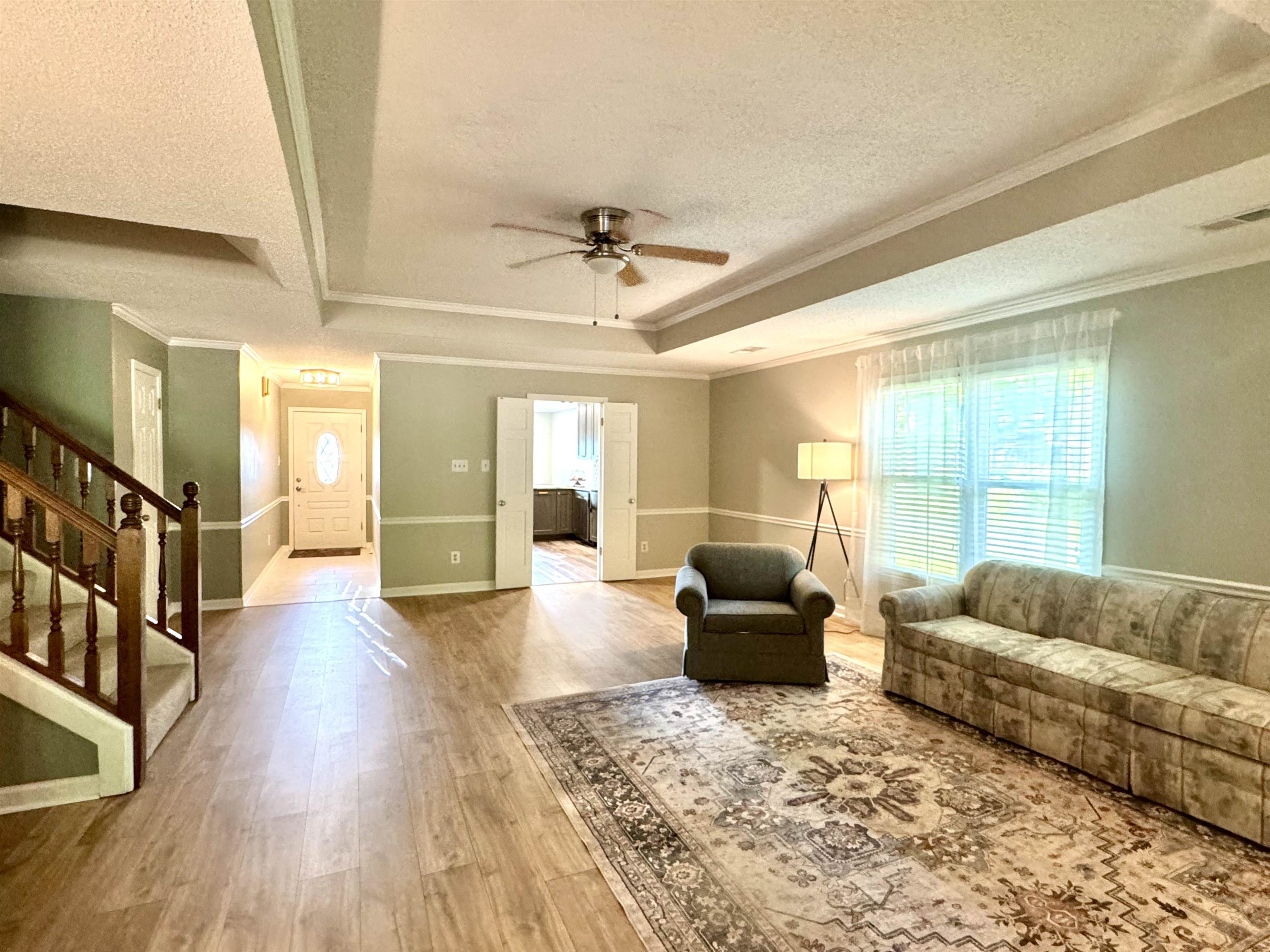 641 Hermitage Trail Collierville, TN 38017 - Photo 16 of 24 Open concept living area featuring wood-finish flooring, a tray ceiling, and crown molding