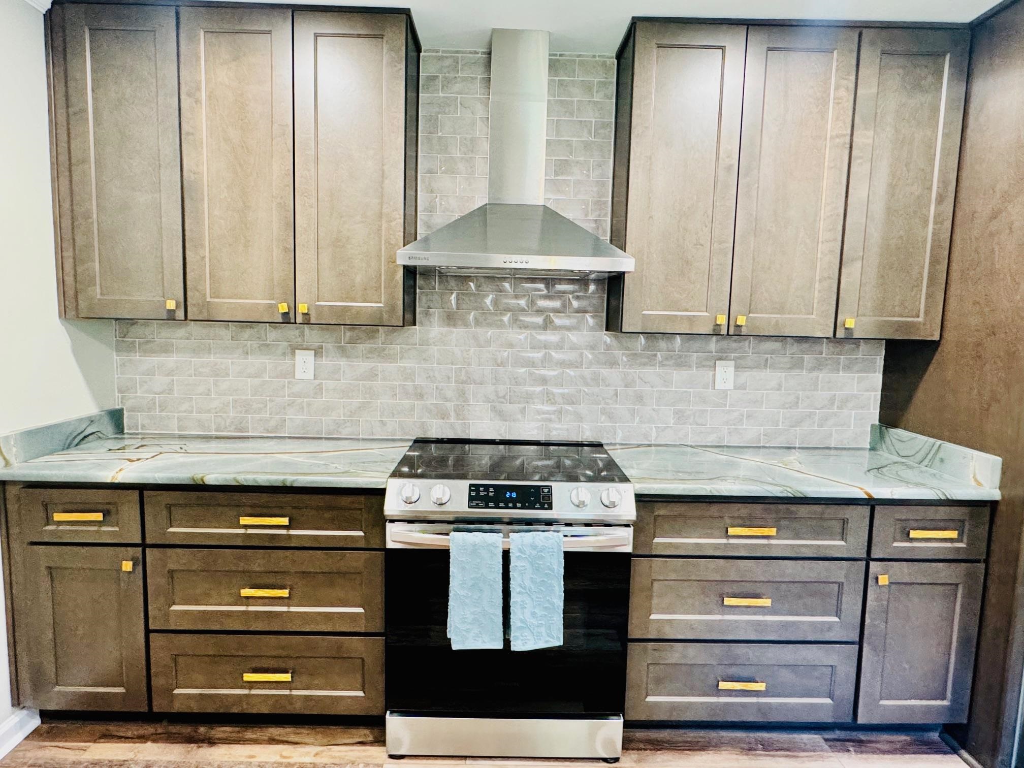 641 Hermitage Trail Collierville, TN 38017 - Photo 8 of 24 Kitchen featuring stainless steel range with electric cooktop, light stone counters, light wood-style flooring, and decorative backsplash