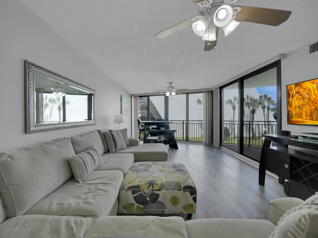 a living room with furniture flat screen tv and a large window