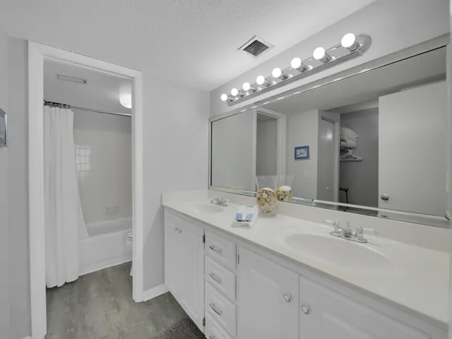 a bathroom with double vanity and a mirror