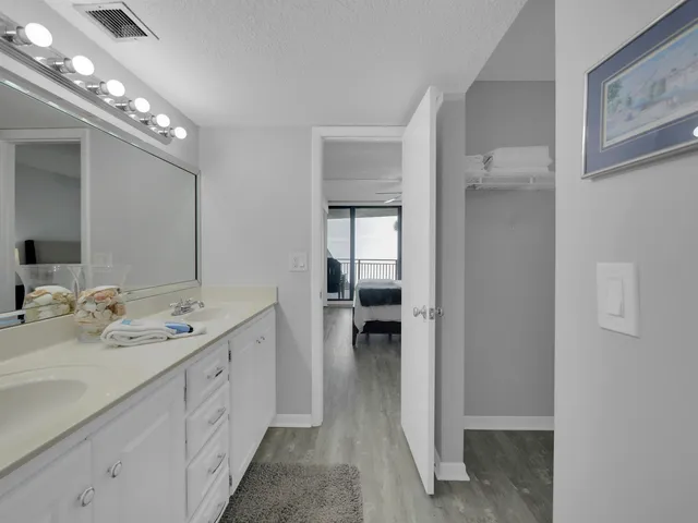 a spacious en suite bathroom with a double vanity sink a mirror and shower