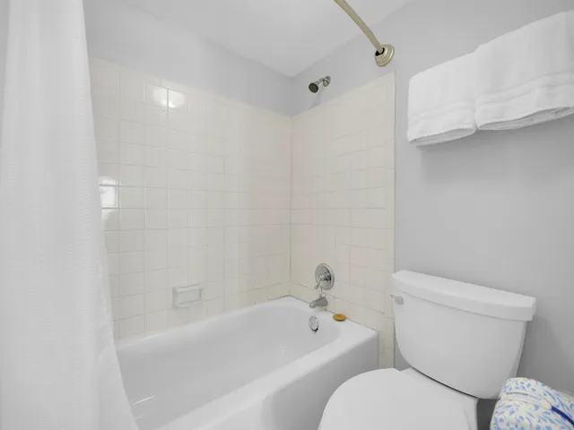 a white toilet sitting next to a bath tub