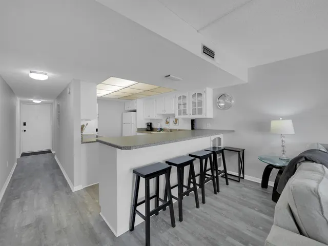 a kitchen with stainless steel appliances a table chairs refrigerator and microwave