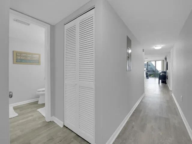 a view of a hallway with a livingroom and a bathroom