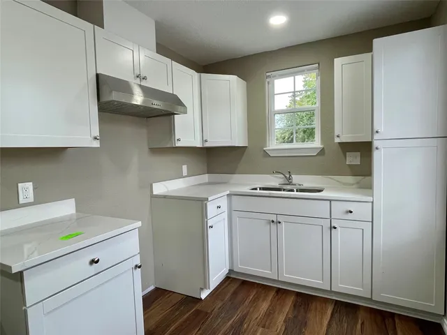 a kitchen with a sink cabinets and wooden floor