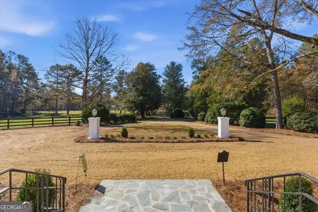 a living room with stainless steel appliances kitchen island granite countertop a stove a refrigerator a sink a dining table and chairs with wooden floor