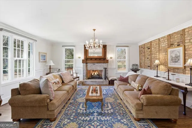 a living room with furniture a flat screen tv and a chandelier
