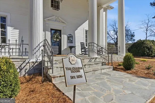 a kitchen with stainless steel appliances a dining table chairs refrigerator and sink