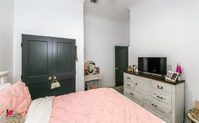 a bedroom with a bed and a flat screen tv