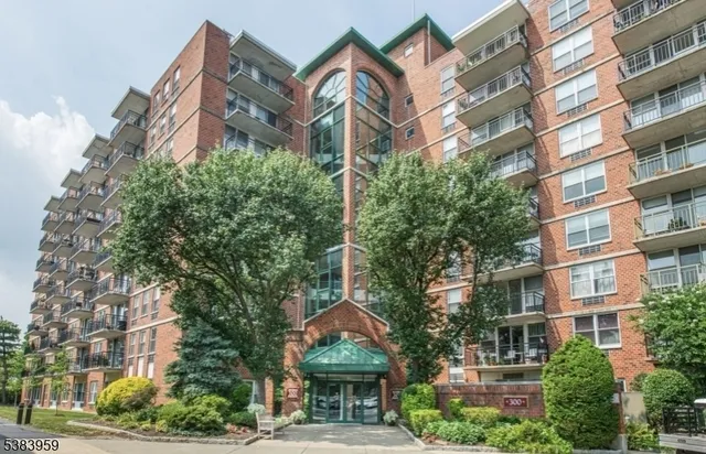 a front view of a multi story building with a yard