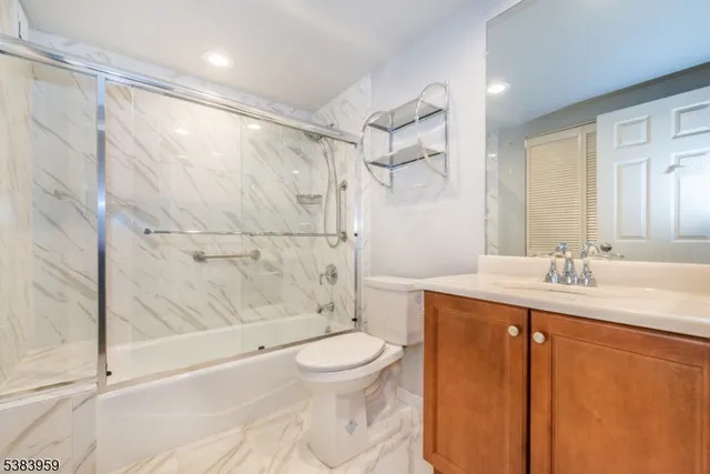 a bathroom with a granite countertop sink toilet and shower