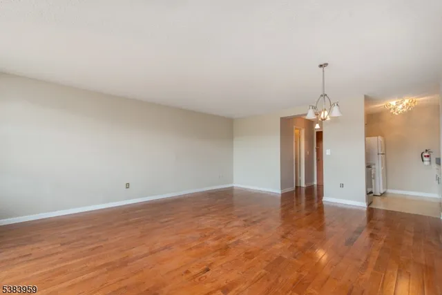 a view of a room with wooden floor and a ceiling fan