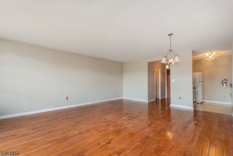 300 Main Street, Unit 716 Little Falls, NJ 07424 - Photo 4 of 24 a view of a room with wooden floor and a ceiling fan