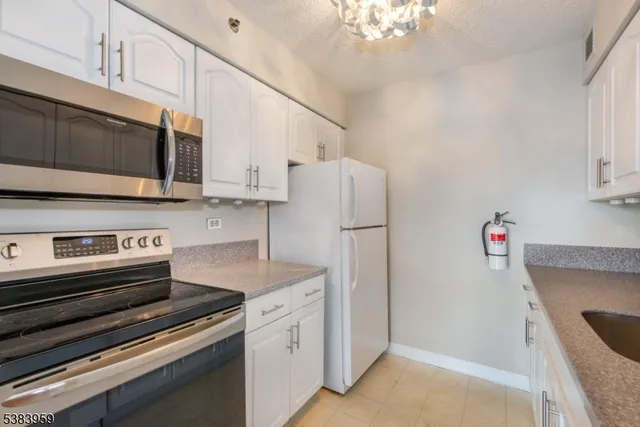 a kitchen with appliances a sink and cabinets