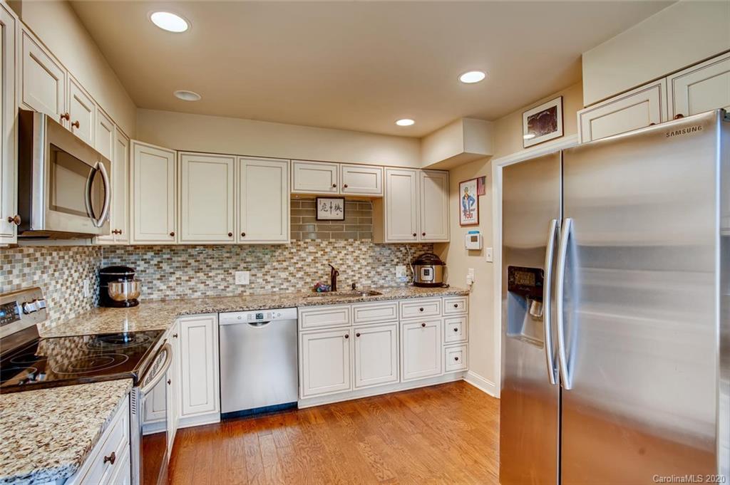 2147 Manawa Lane Tega Cay, SC 29708 - Photo 8 of 28 a kitchen with stainless steel appliances granite countertop a refrigerator a sink and white cabinets