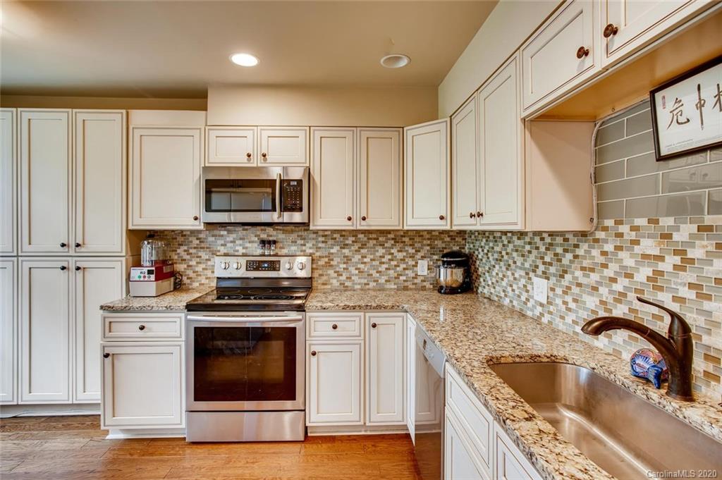 2147 Manawa Lane Tega Cay, SC 29708 - Photo 10 of 28 a kitchen with granite countertop a sink wooden cabinets and stainless steel appliances