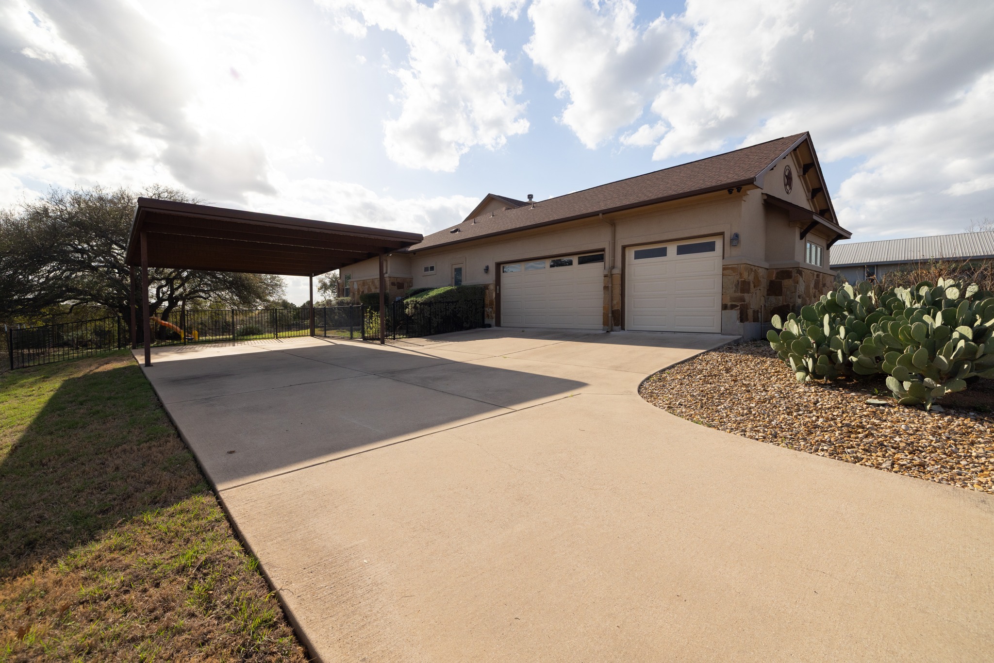 204 Skyline Road Georgetown, TX 78628 - Photo 9 of 40 View of side of home with stone siding, a garage, concrete driveway, and stucco siding