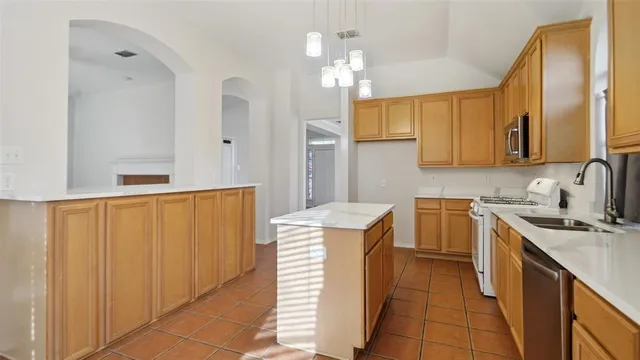 a kitchen with a sink a stove cabinets and a window
