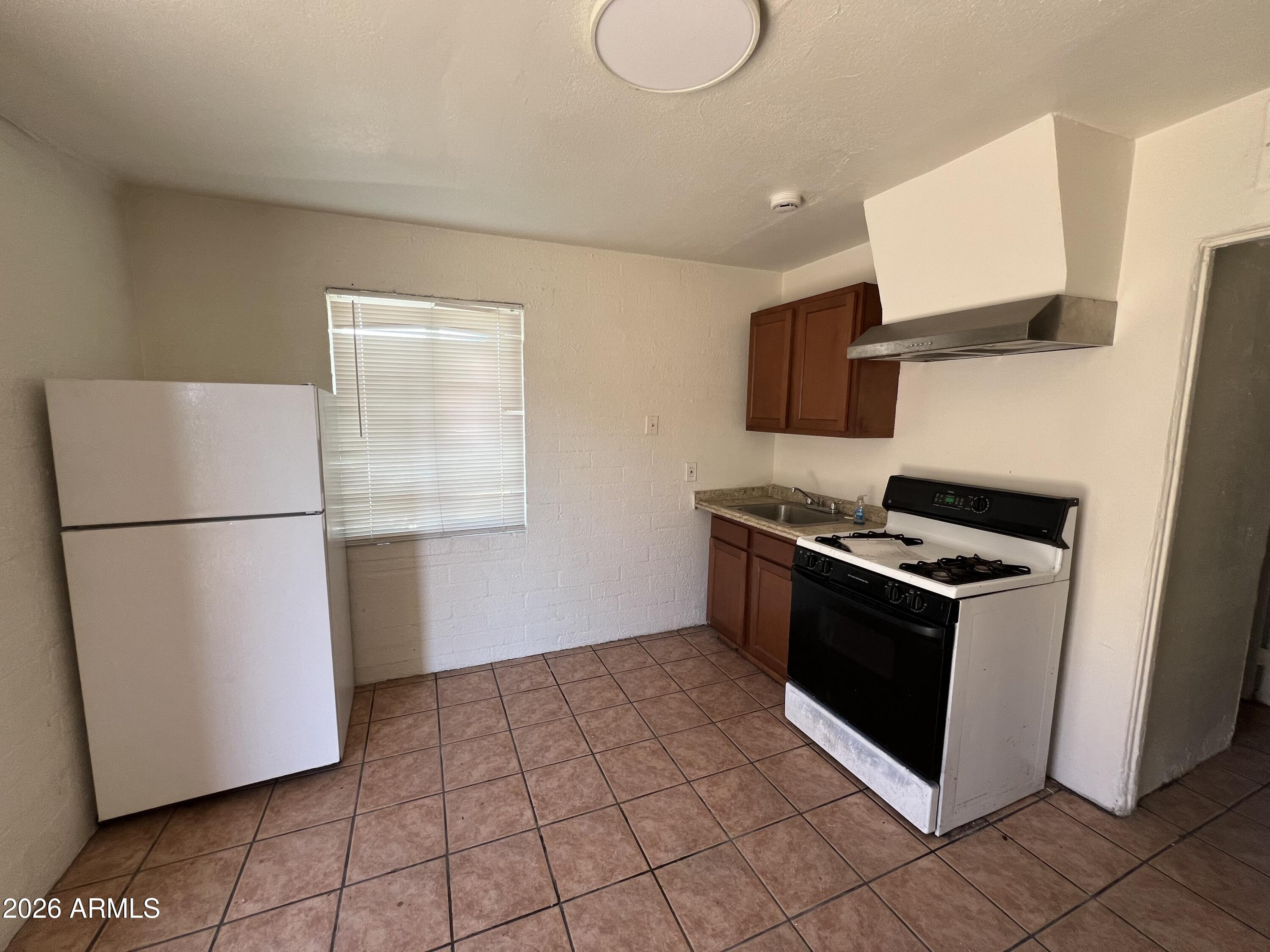 712 West Fillmore Street Phoenix, AZ 85007 - Photo 4 of 5 a kitchen with a stove cabinets and a refrigerator